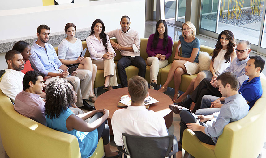 A group of people sitting around each other in a circle.