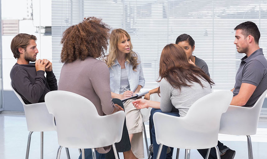 A group of people sitting around in chairs.