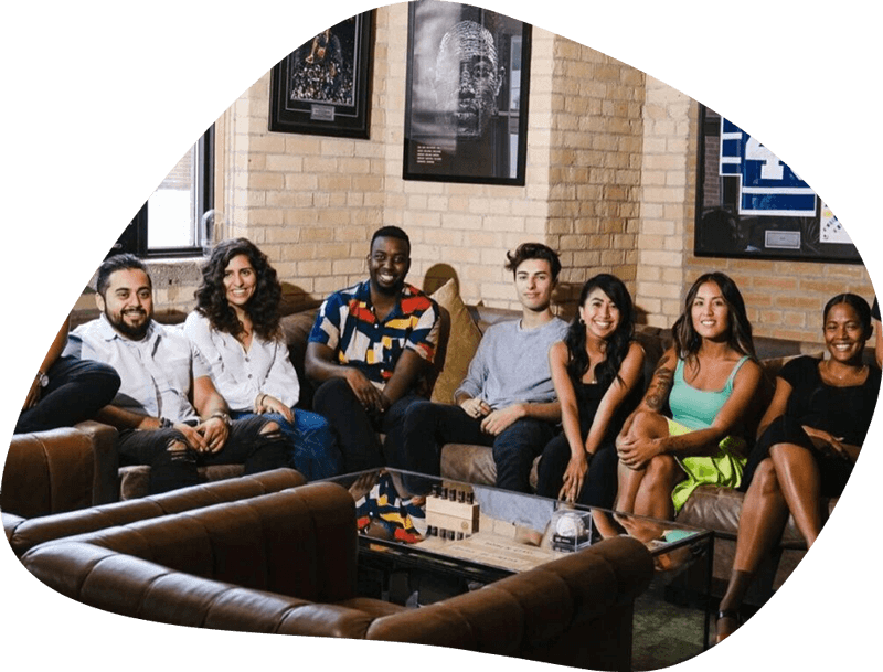 A group of people sitting on couches in front of a wall.